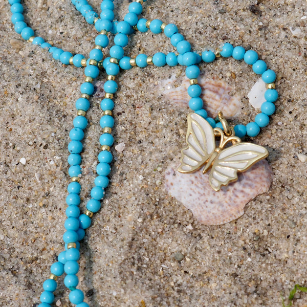 KARAN WHITE ENAMEL BUTTERFLY PENDANT ON TURQUOISE BEADS